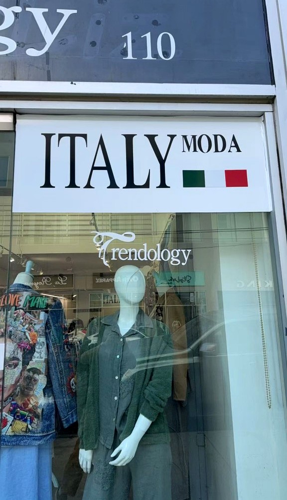 Trendology showroom window with Italy Moda sign and a mannequin in green knit